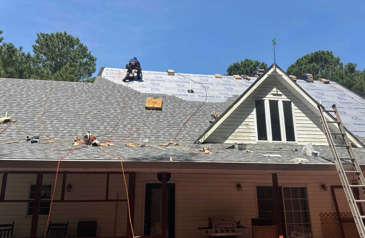 New architectural shingles being installed up the main slope over white synthetic underlayment
