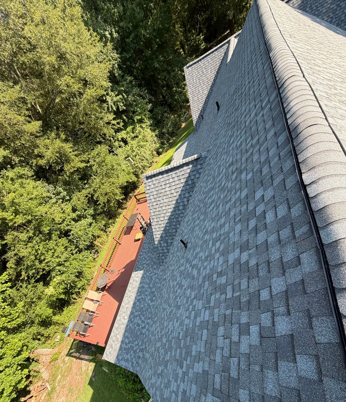 Straight courses of grey architectural shingles running into a capped hip and ridge